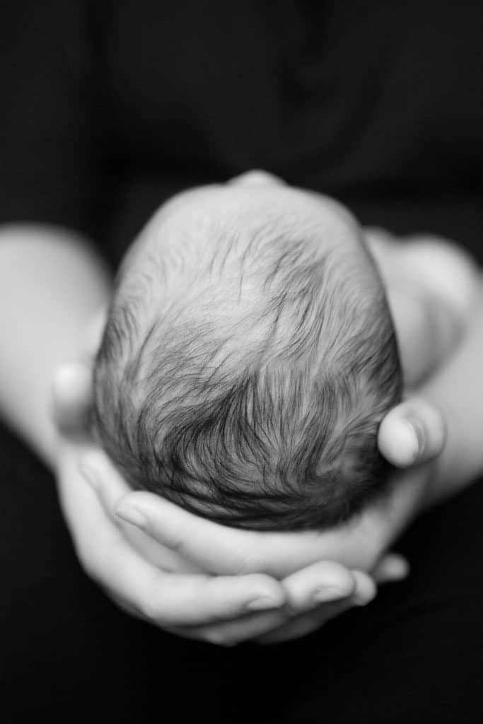 newborn head in fathers hands