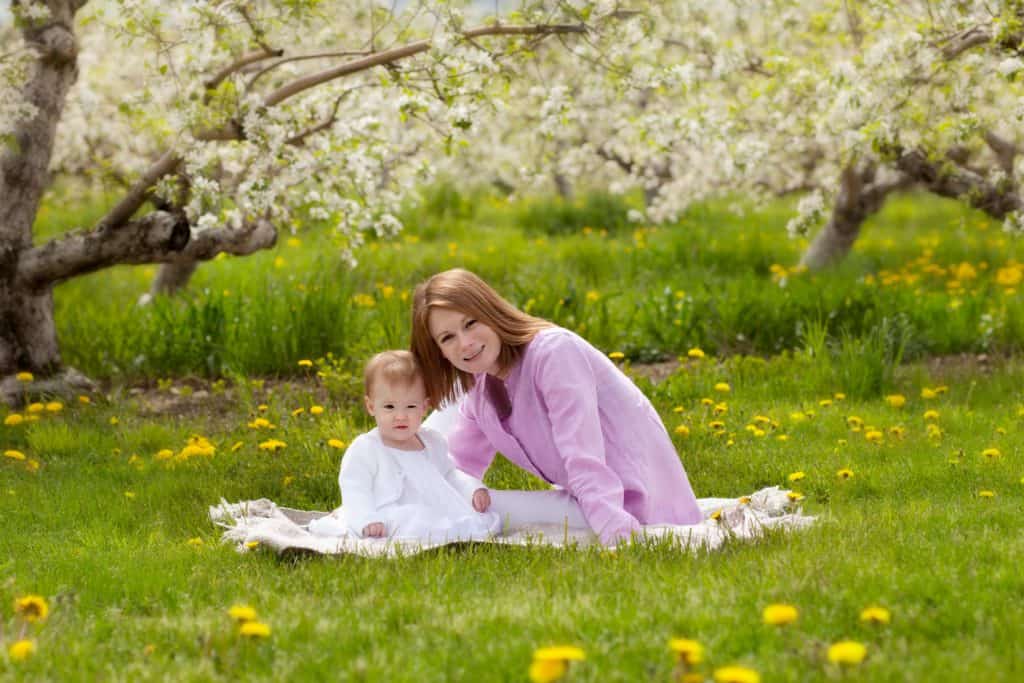 Spring mini sessions - mom on grass of apple orchard with daughter - www.daniellebustamante.com - #springminisessions #nhspringminisession