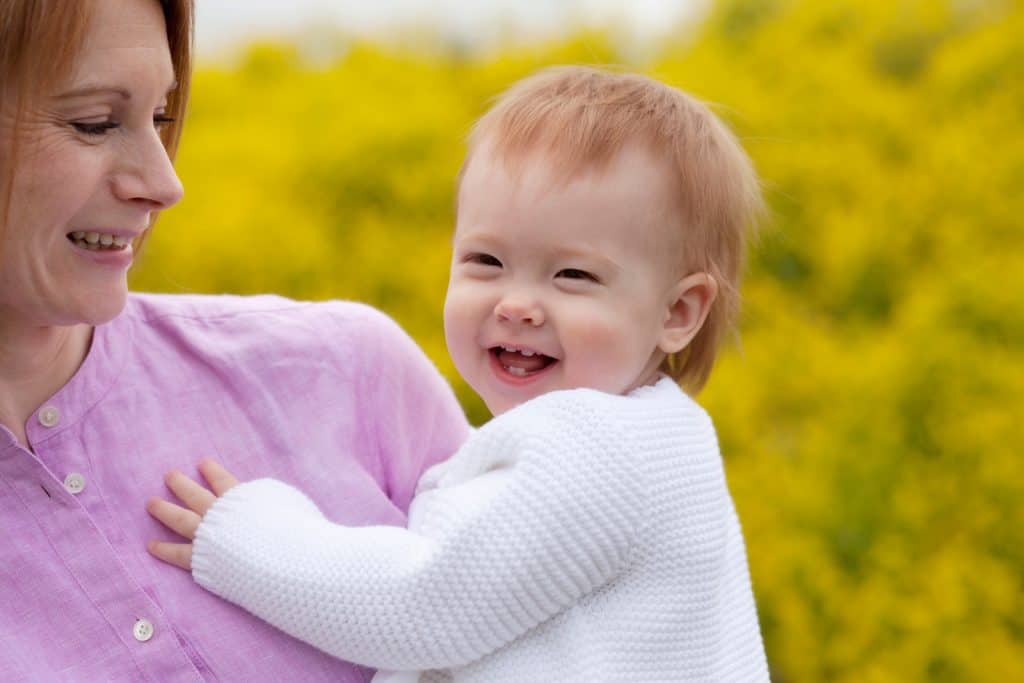 Spring Mini Session - Mother Holding Smiling Baby - yellow blossoms in back - www.daniellebustamante.com - #springmini #nhspringminisession