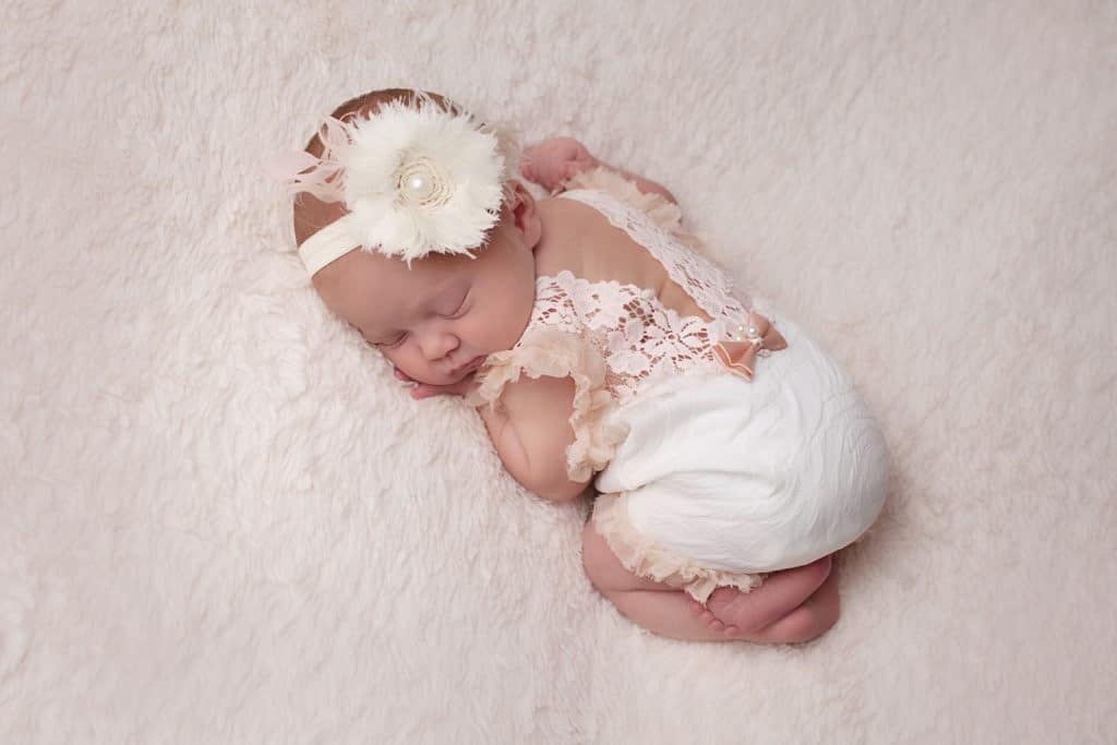 newborn on tummy in lace romper