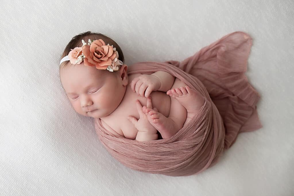 Windham NH Newborn Portrait baby girl in light pink wrap on her back