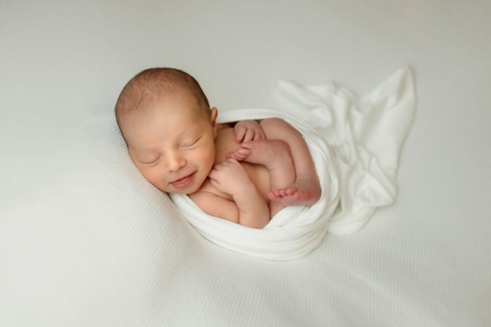 NH Newborn - Wrapped in ivory wrap in womb pose