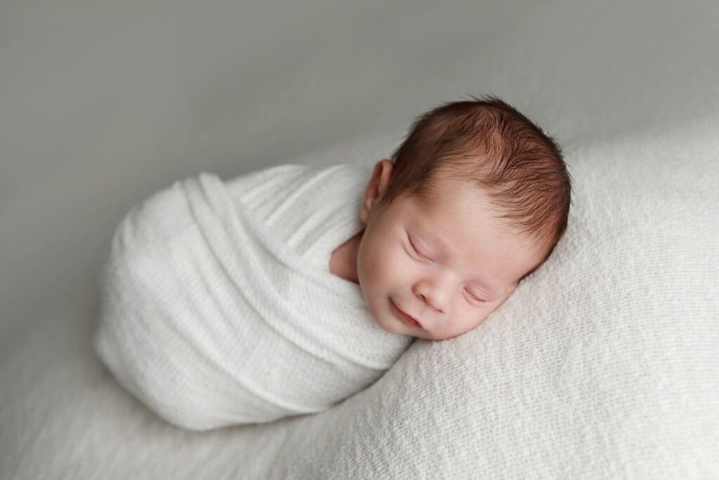 newborn portrait of baby boy wrapped in ivory wrap