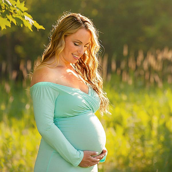 Londonderry NH Maternity Portrait - Aqua colored dress looking at belly in sunset