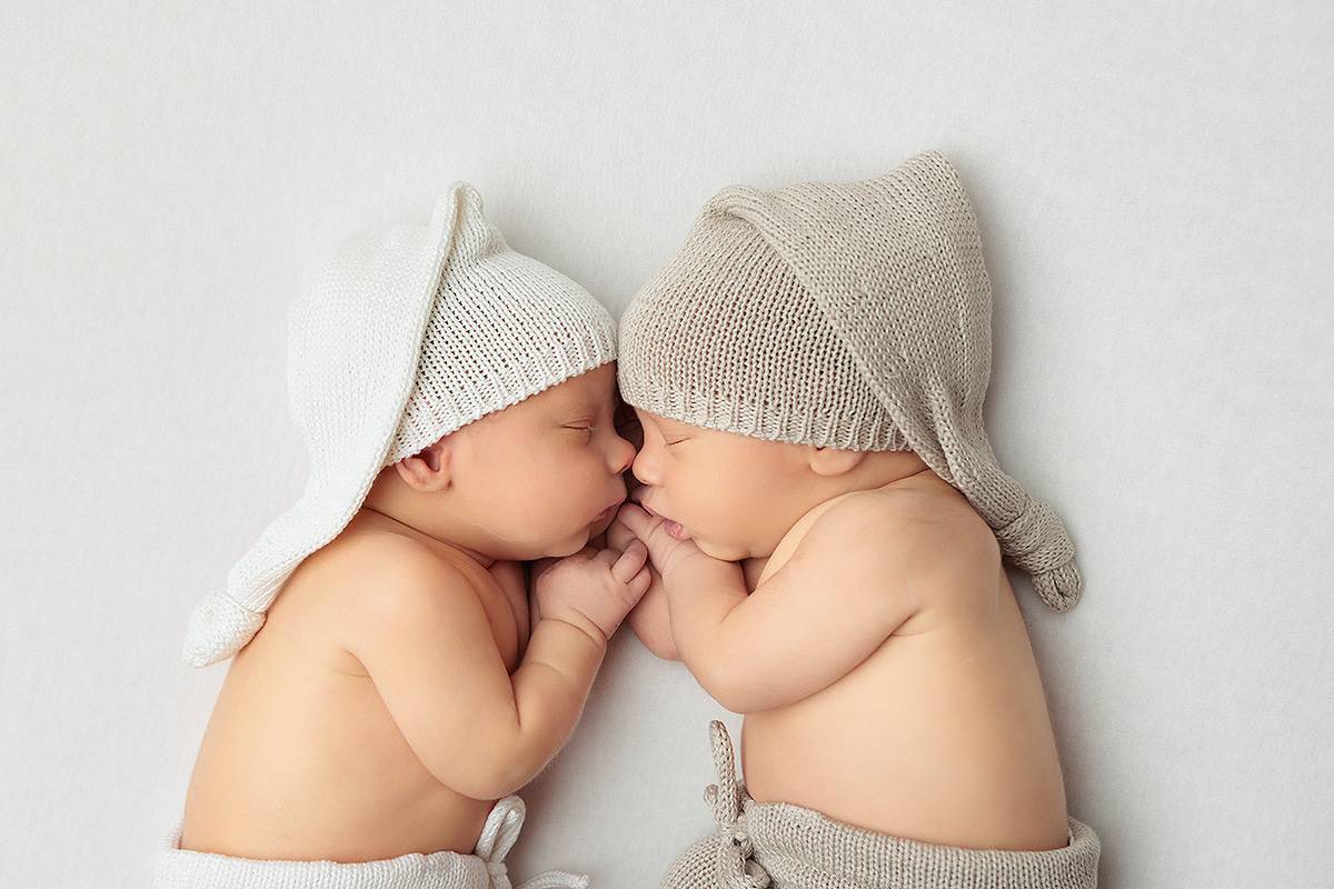 Windham NH Twin Newborn Session - Twin boys face to face holding hands.