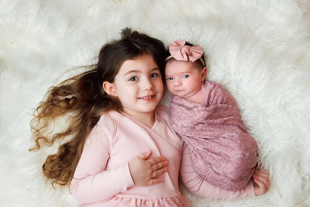 Southern NH Newborn portrait of sibling and newborn looking at camera.