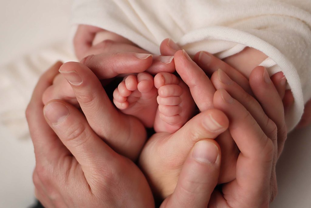 Salem NH newborn portrait of baby's feet in parents hands.