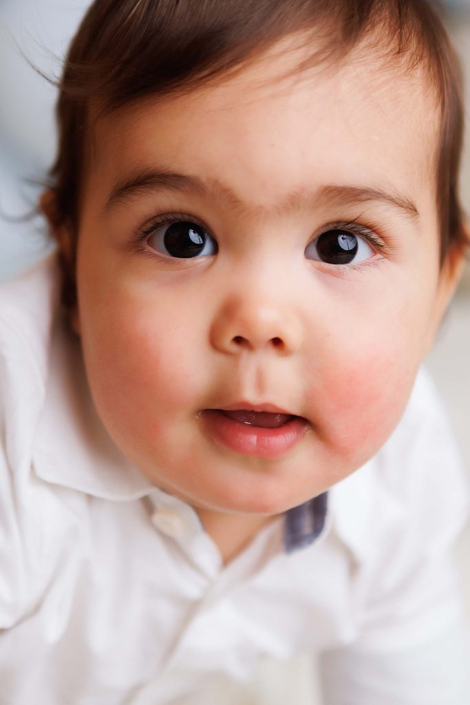 Close up of little boys face for a one year old cake smash session near me.