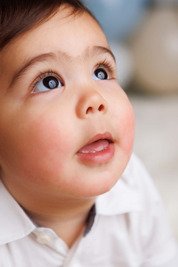 Cake Smash session. Close up of little boy looking up at camera.