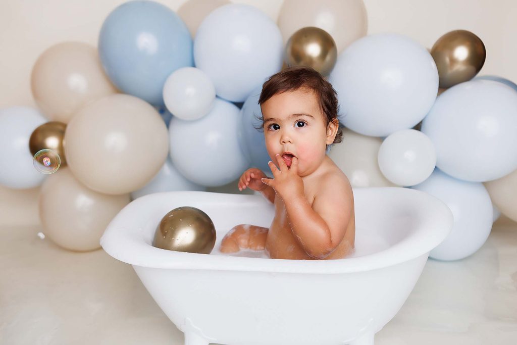 One year old sitting tub for a bubble bath after cake smash portrait.