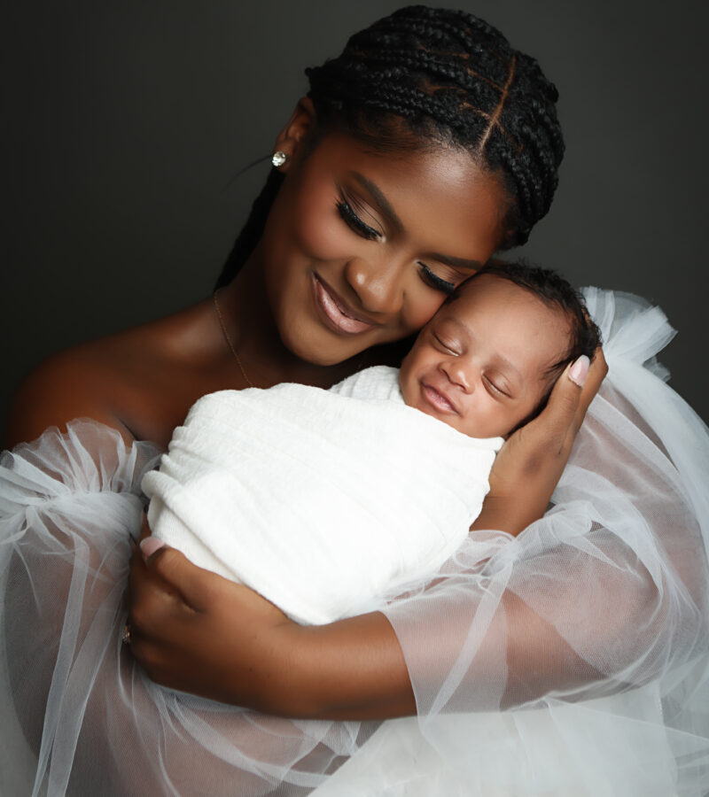 Baby Boy being snuggled by mother while wearing an ivory newborn wrap. boston newborn portrait near me.