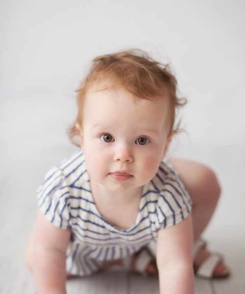 One year old crawling towards camera during her cake smash session in NH.