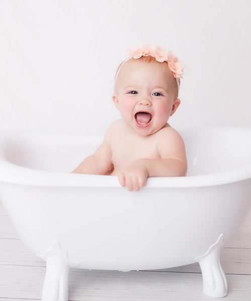 One year old little girl having fun in a tubby after cake smash in NH.