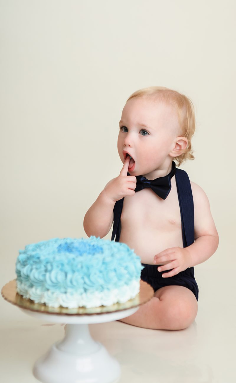 Windham NH One Year old eating cake during his cake smash session.
