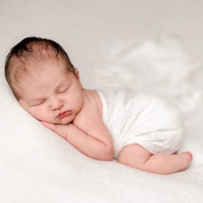 Newborn Portrait of baby boy on his tummy in the bum up pose in an ivory wrap. Boston Newborn Portrait Session.