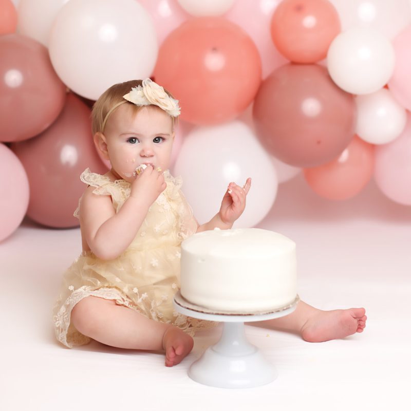 One Year old girl eating cake for her Boston cake Smash Session.
