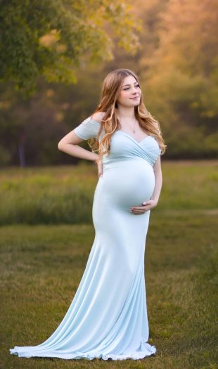 NH Maternity Portrait of expectant mother wearing a light blue maternity dress posing in an open field in NH.