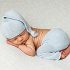 NH Newborn Portrait of Baby boy in knit light blue pants and sleepy cap.