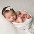 NH Newborn Portrait in ivory wrap on ivory backdrop with floral ivory headband.